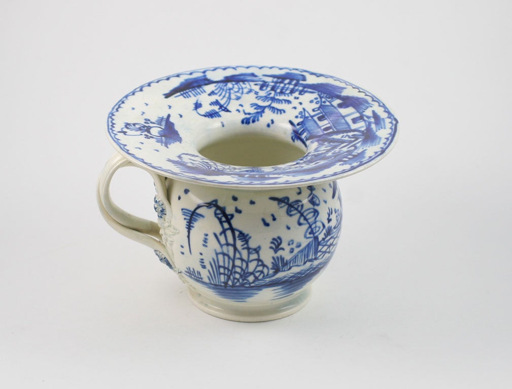 A rare English pearlware pottery blue and white Lady's Spittoon decorated with a Oriental landscape, double twist handles with flowers florettes